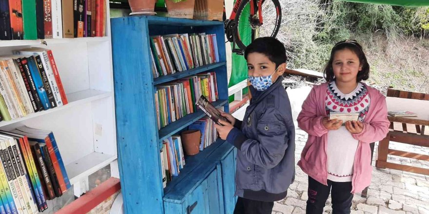 Evin bahçesine kurduğu kütüphanede mahallece kitap okuyorlar