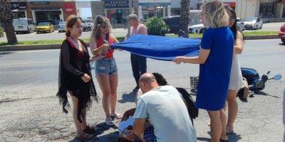 Kazada yaralanan motosikletliye plaj havlusuyla gölge yaptılar