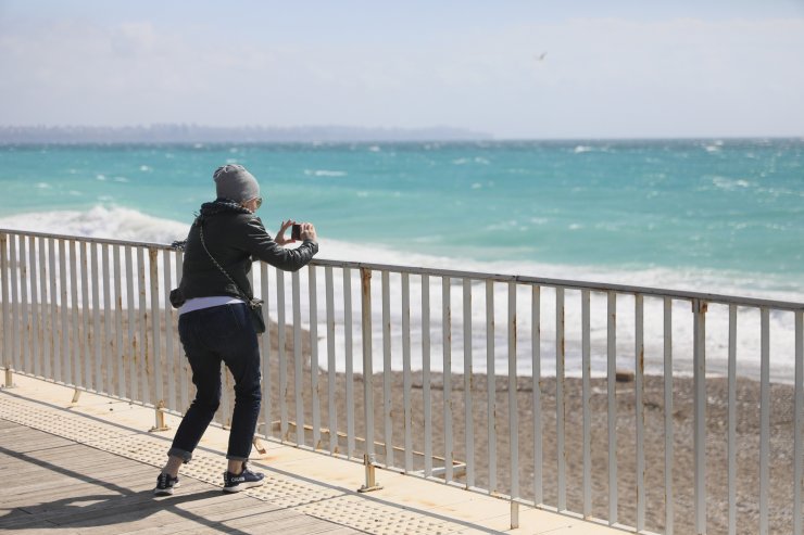 Rüzgarlı havada sahilde dalgalarla fotoğraf çektirdiler